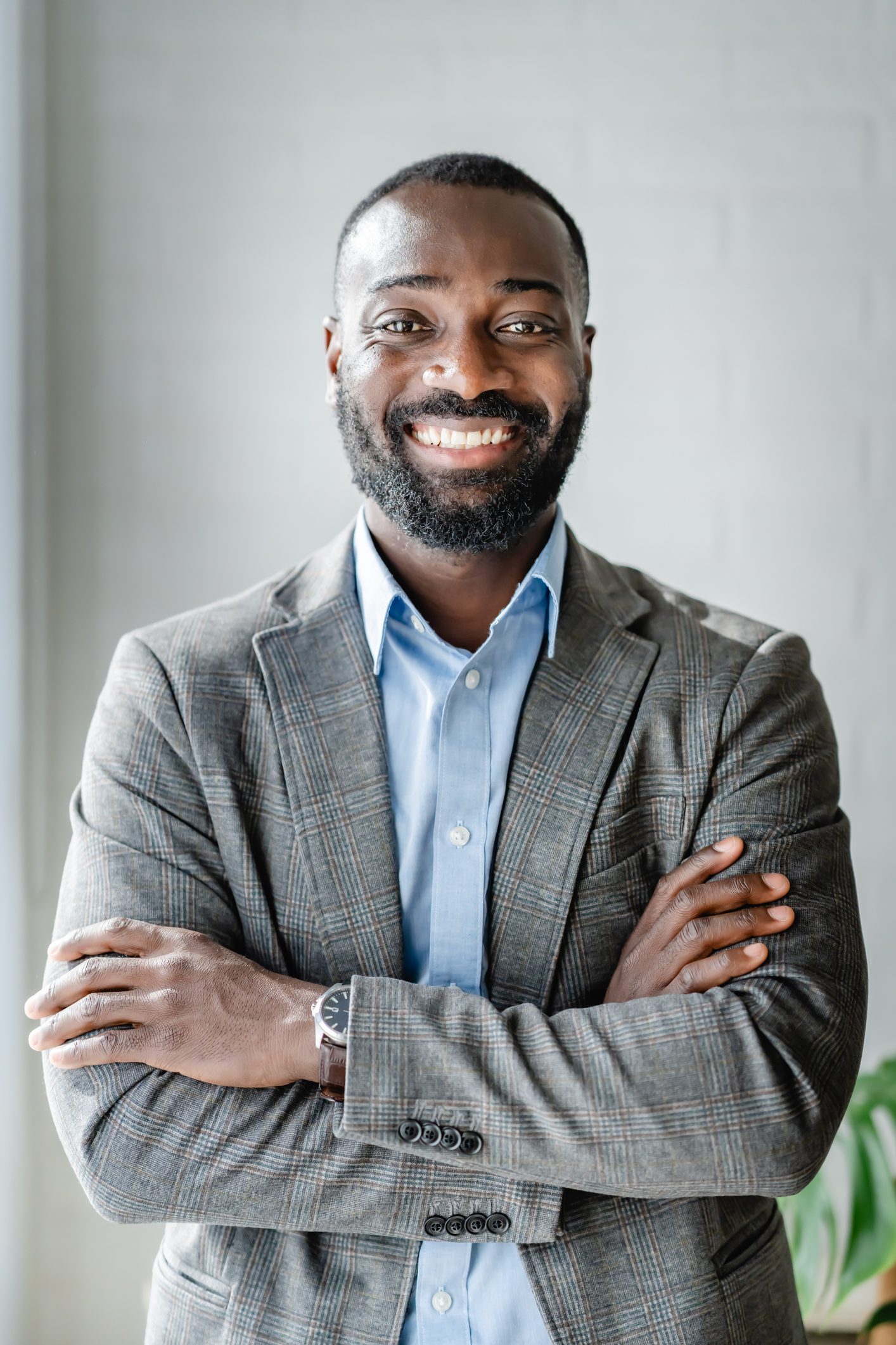 a smiling man wearing a grey suite
