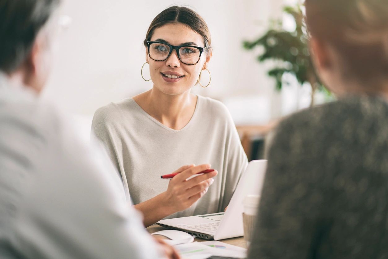 a woman talking with 2 new customers