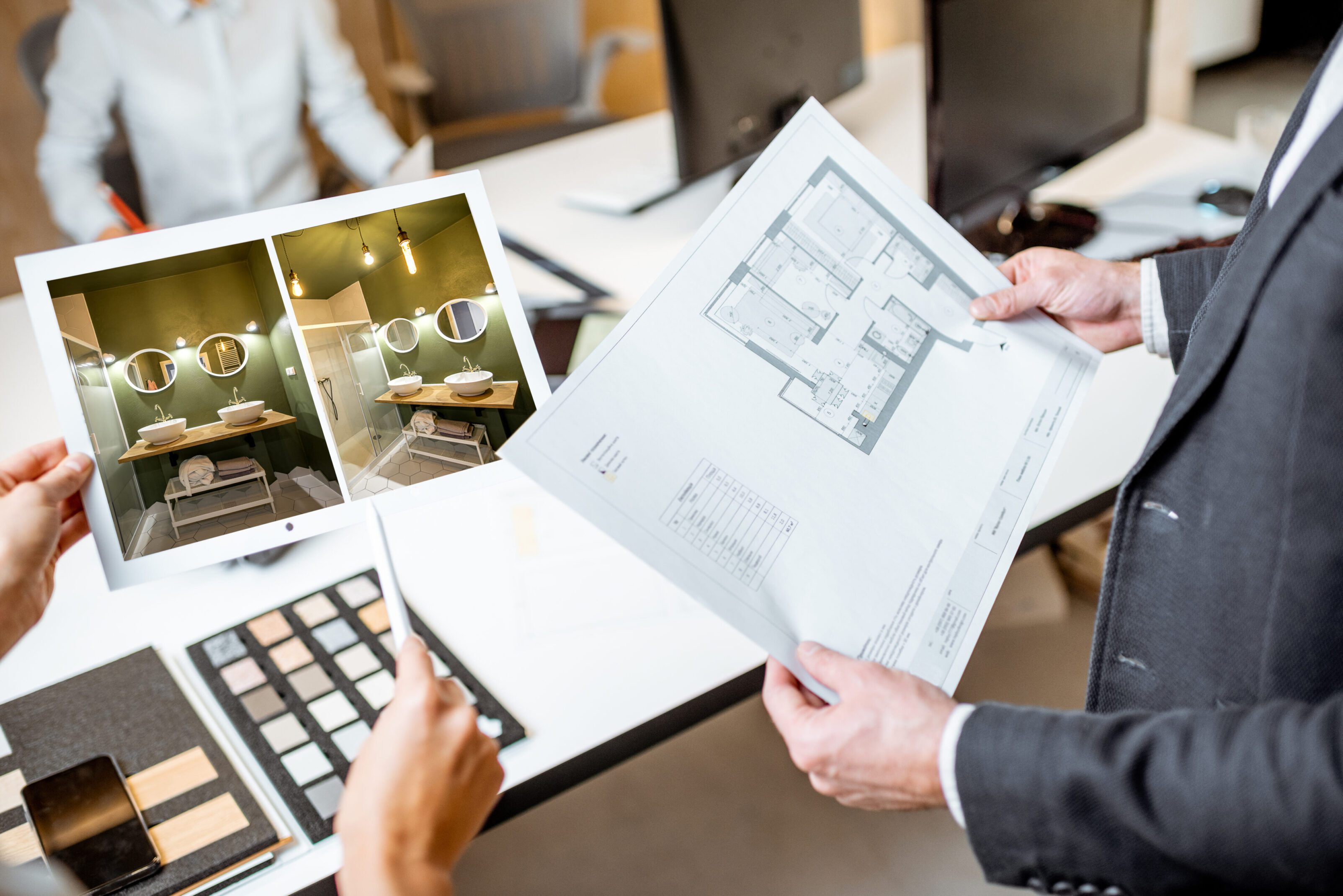 Architects reviewing floor plans and interior design samples.