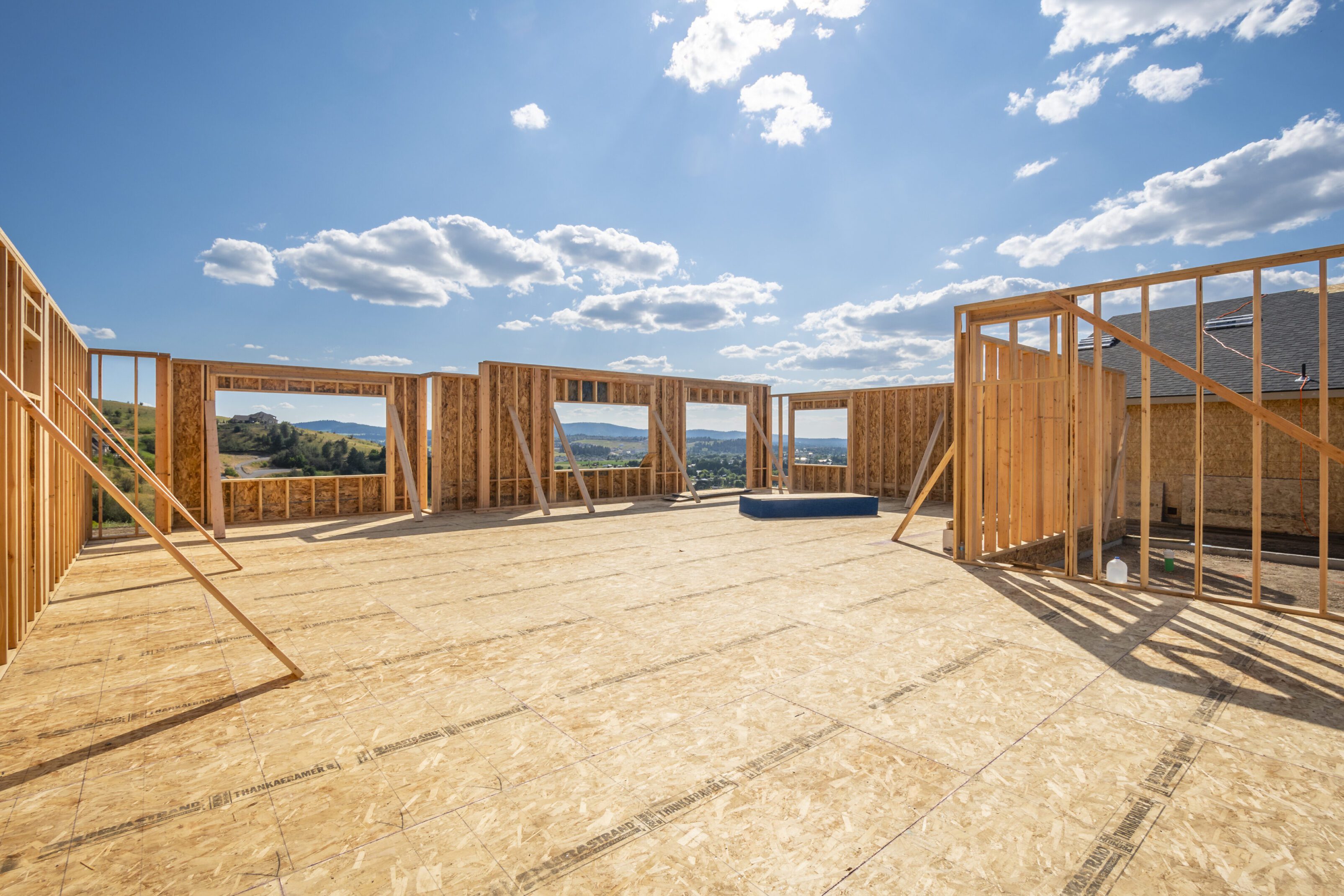 Wooden framework of a house under clear blue sky construction.