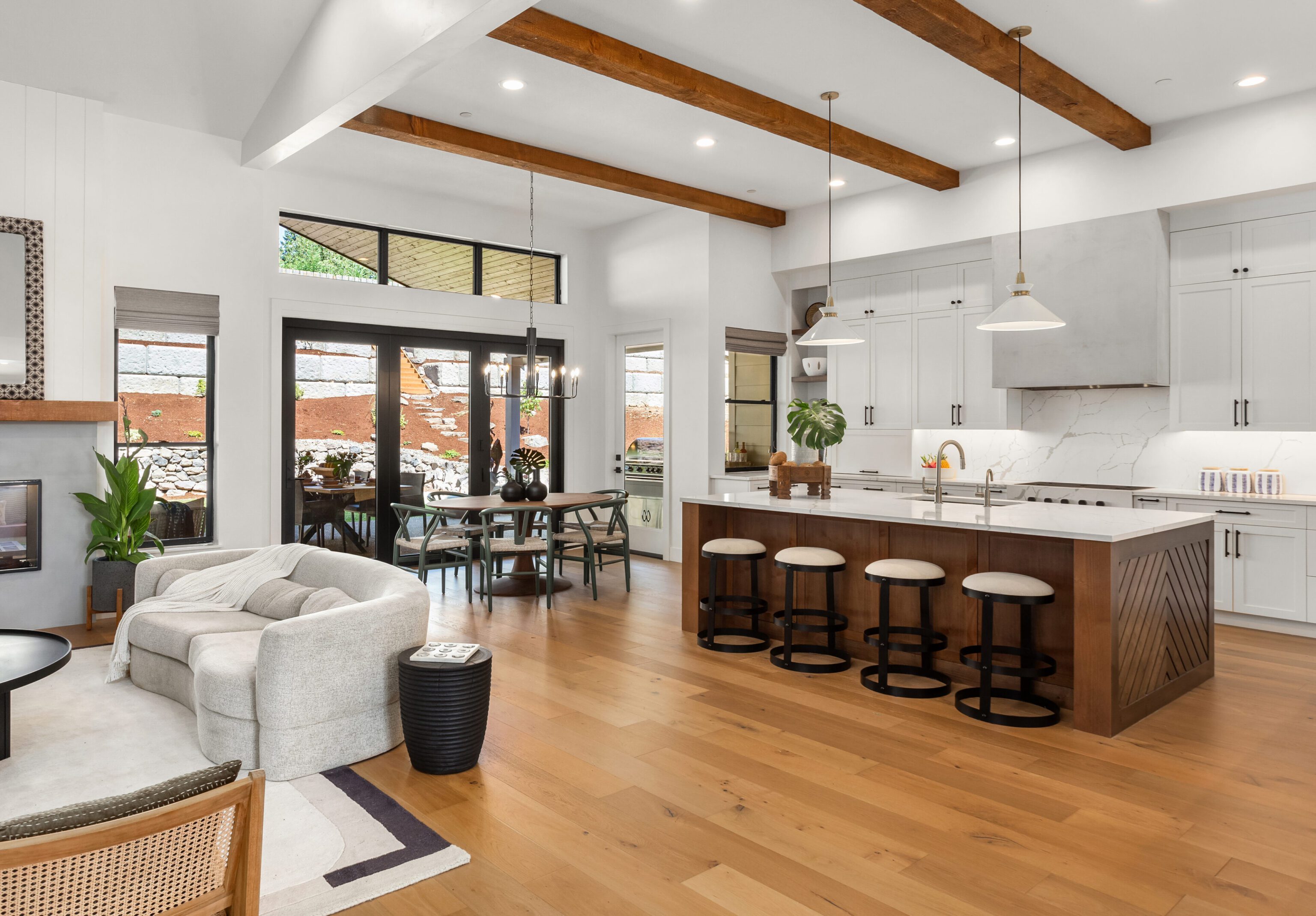 Spacious modern kitchen and living area with wooden floors and ceiling beams.