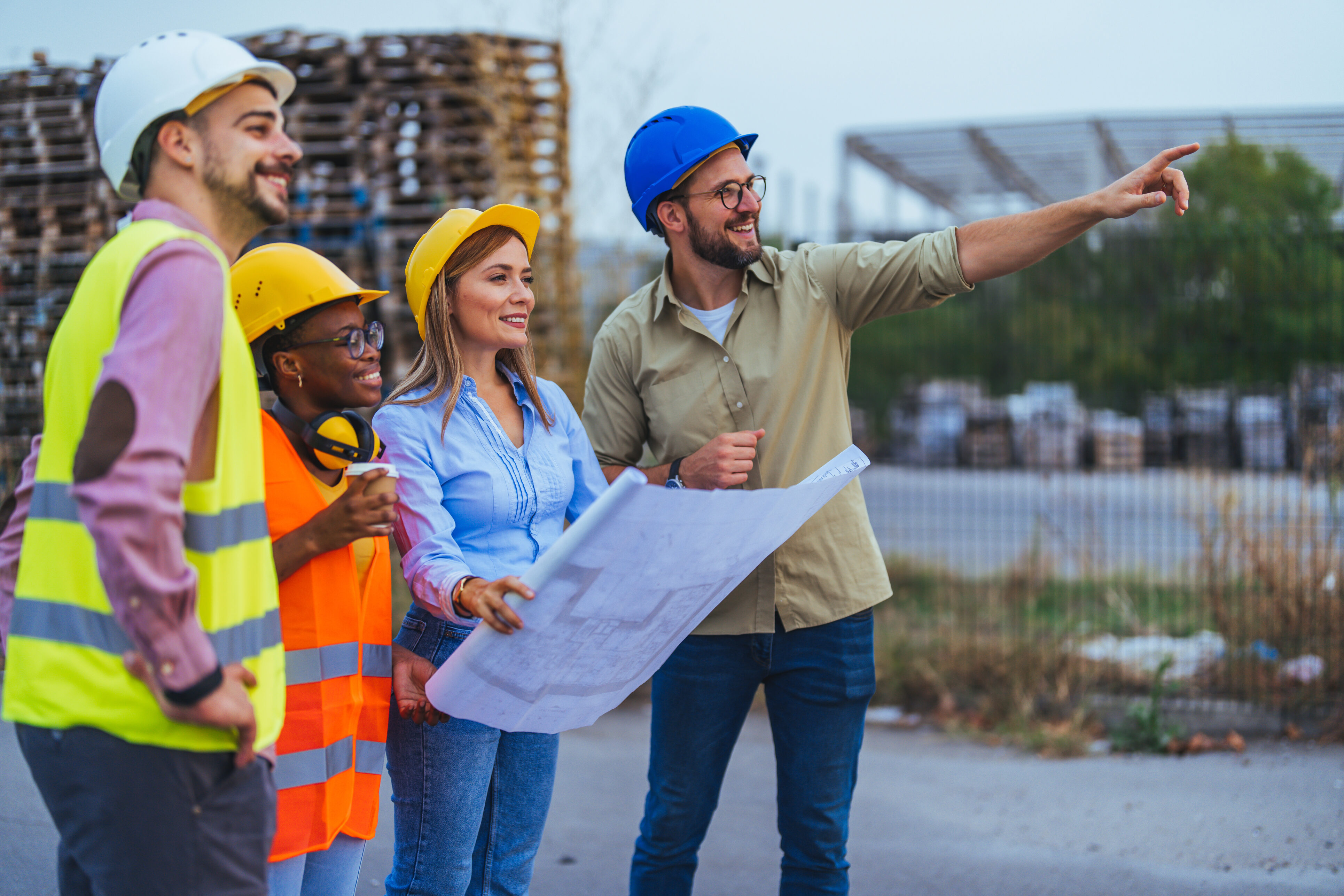 Construction team reviewing blueprints at a building site.