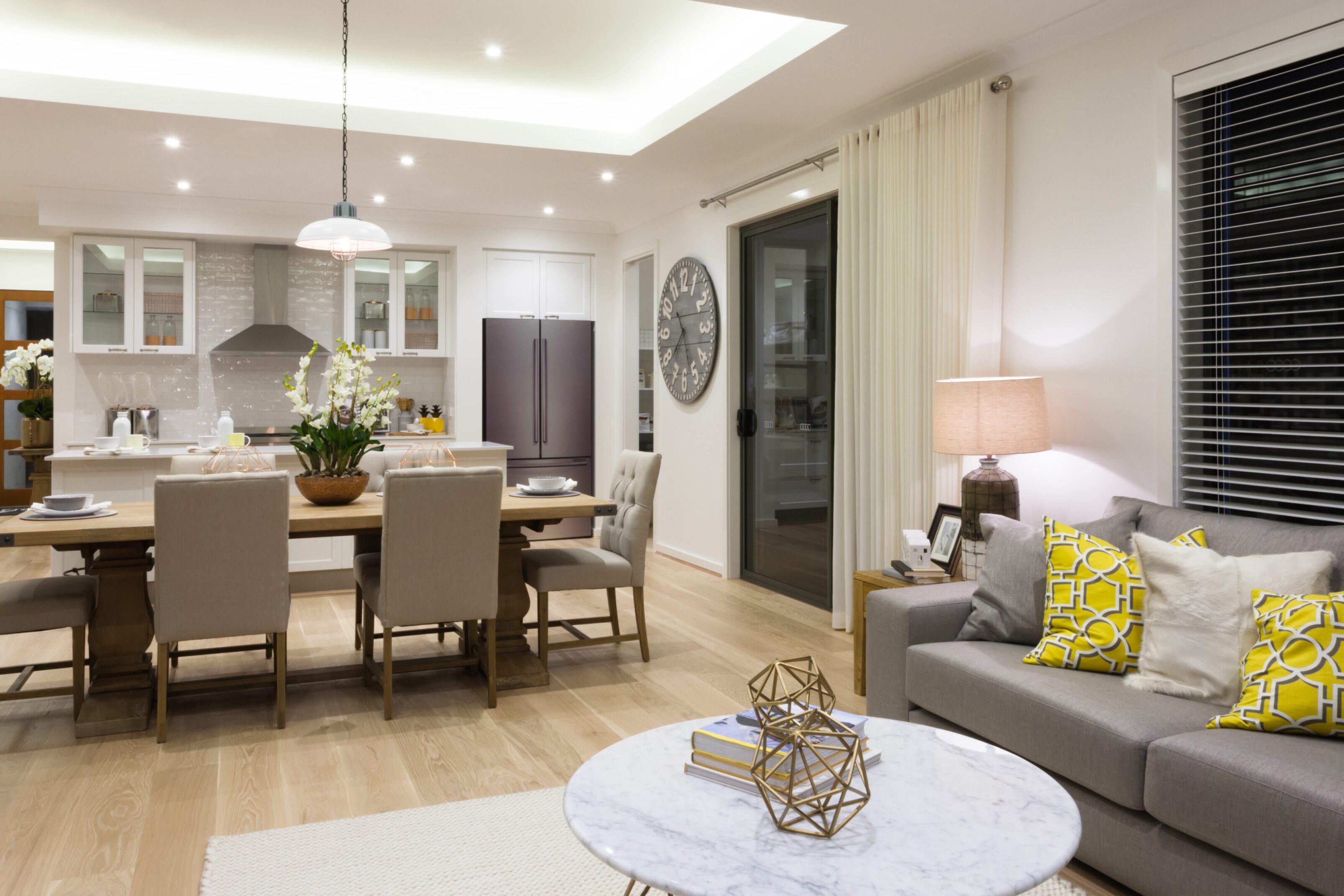 Modern living and dining room with elegant furnishings and warm lighting.
