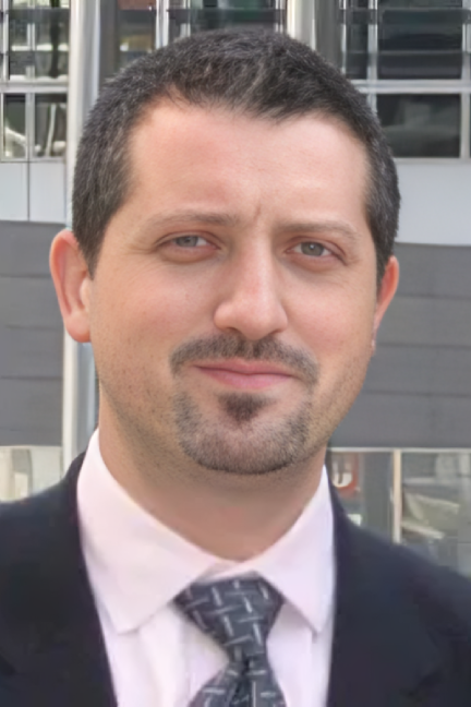 Portrait of a man with short dark hair and a goatee.