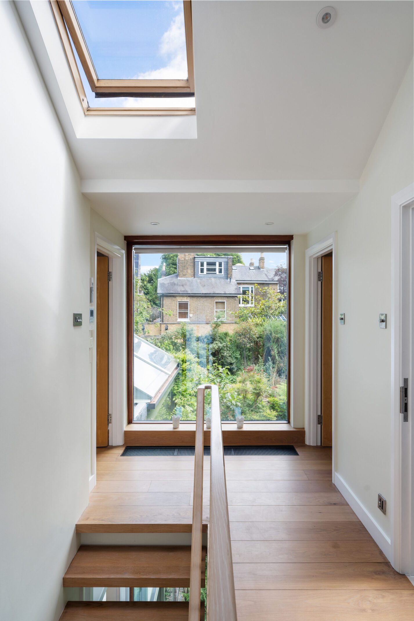 Bright hallway with skylight leading to a garden view.