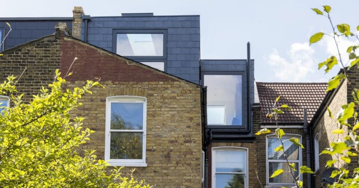 A modern extension added to a traditional brick house.