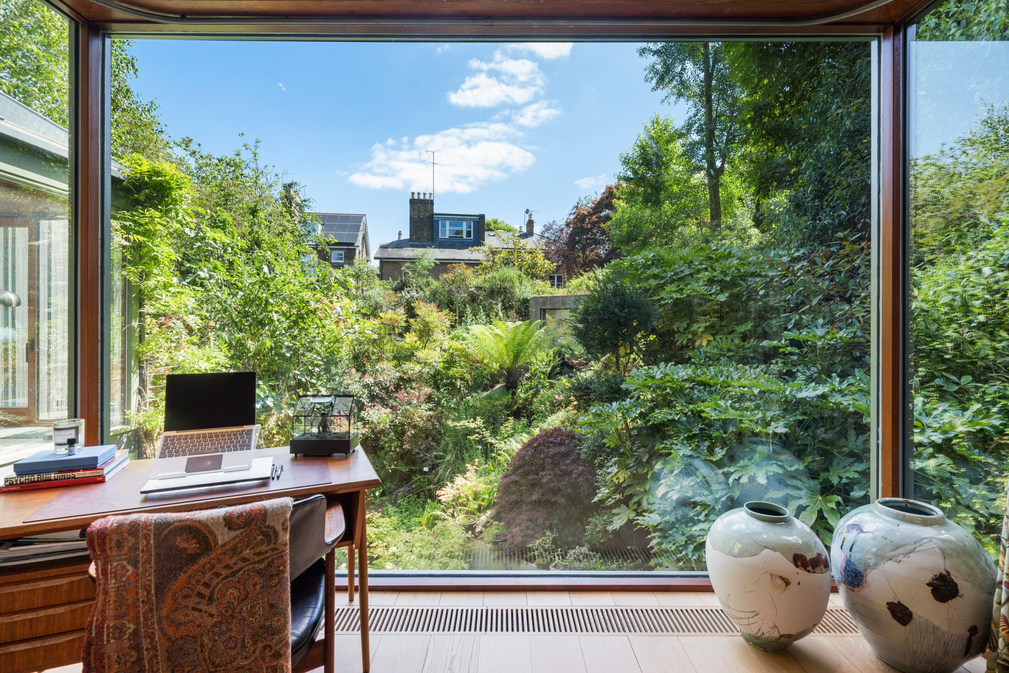 Cozy workspace by a large window overlooking a lush garden.